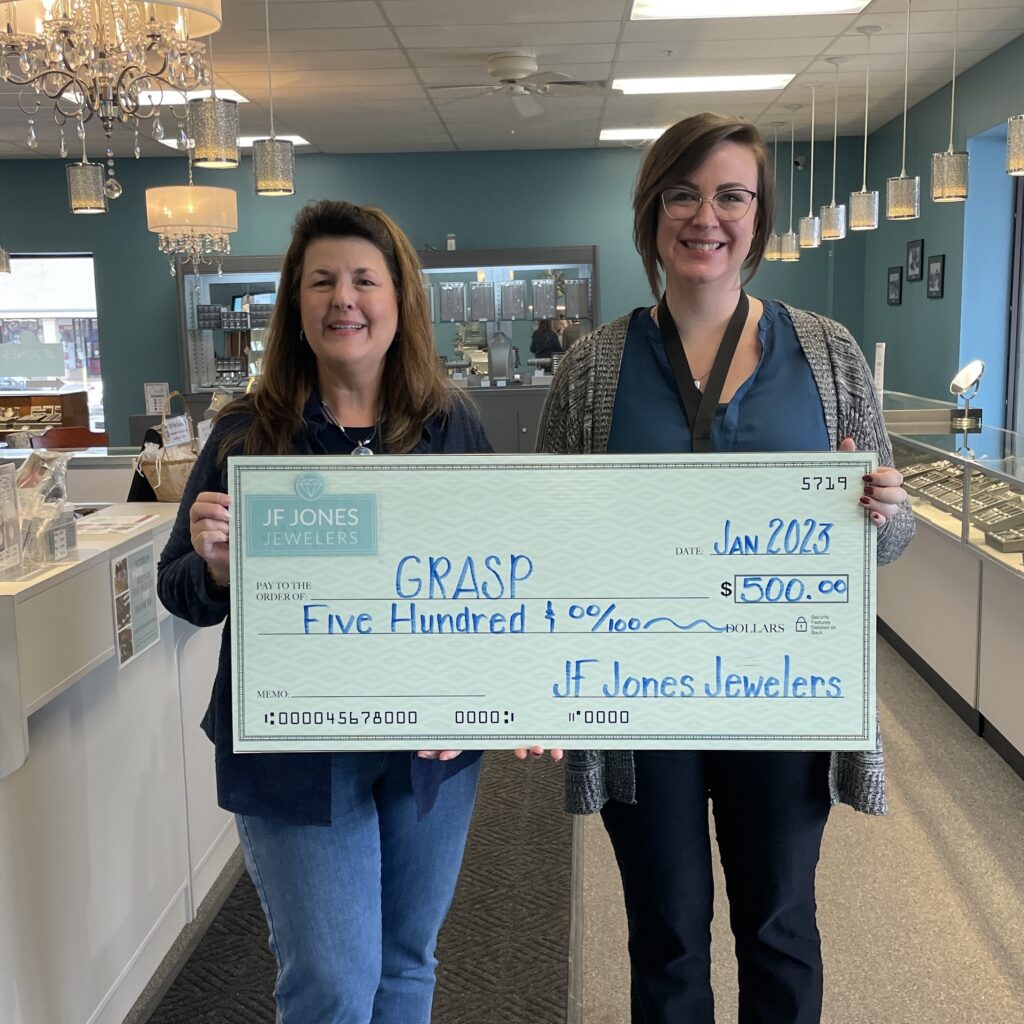 Owner, Brittany Jones Lonthair presenting a check to Tammi Becker, board member of GRASP